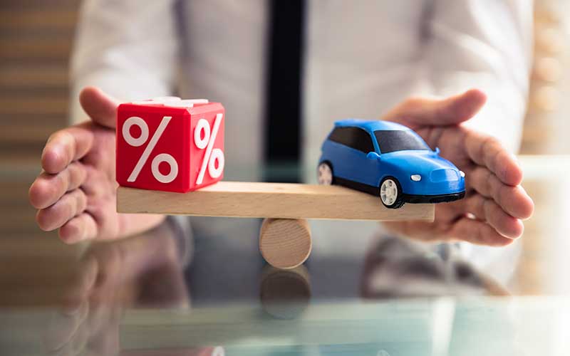 A red cube with a large percentage (%) symbol on its visible sides, representing interest rates